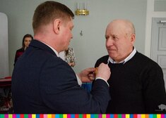Marszałek Malinowski przypina medal mężczyźnie 