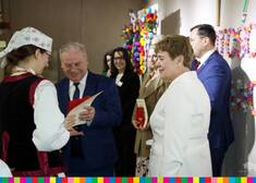 Marszałek Olbryś otrzymuje dyplom od kobiety w stroju ludowym