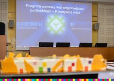 Ujęcie tortu oraz slajdu multimedialnego w sali konferencyjnej