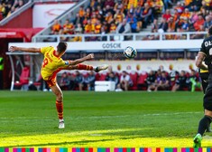 Piłkarz unosi wysoko nogę, aby kopnąć piłkę