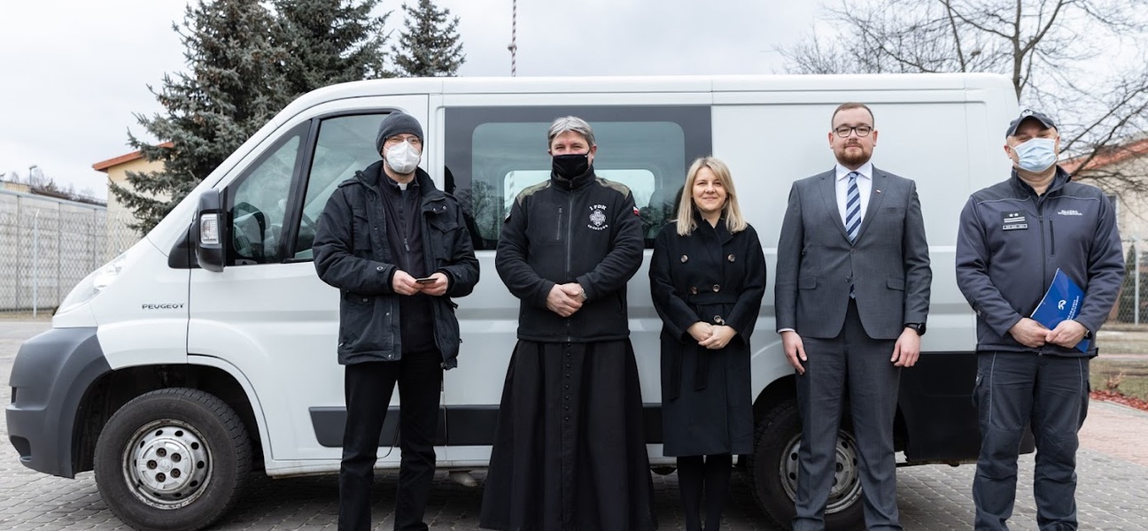 Wicemarszałek Sebastian Łukaszewicz oraz inne osoby przy samochodzie transportowym