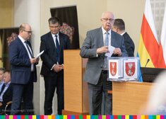Radny Dworzański wrzuca kopertę do urny.