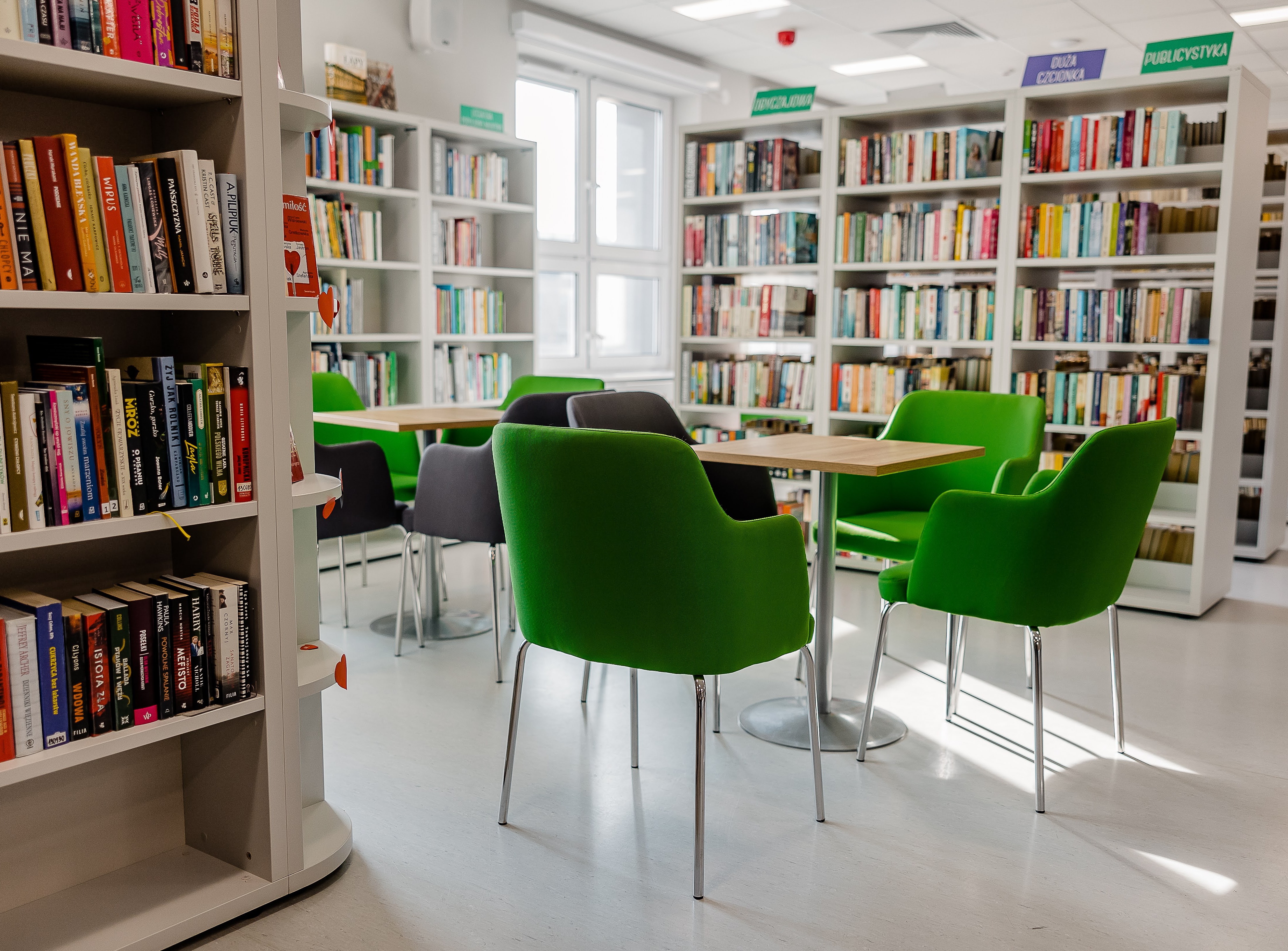 Zielone krzesła w pomieszczeniu wypełnionym półkami z książkami