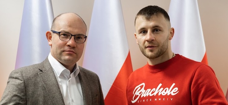 Dwóch mężczyzn na tle biało-czerwonych flag