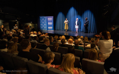 Osoby stoją na scenie Białostockiego Teatru Lalek.
