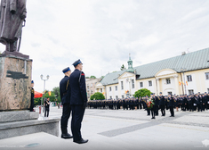 Strażacy stoją pod pomnikiem Piłsudskiego