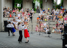 Dzieci tańczący na scenie na tle widowni.
