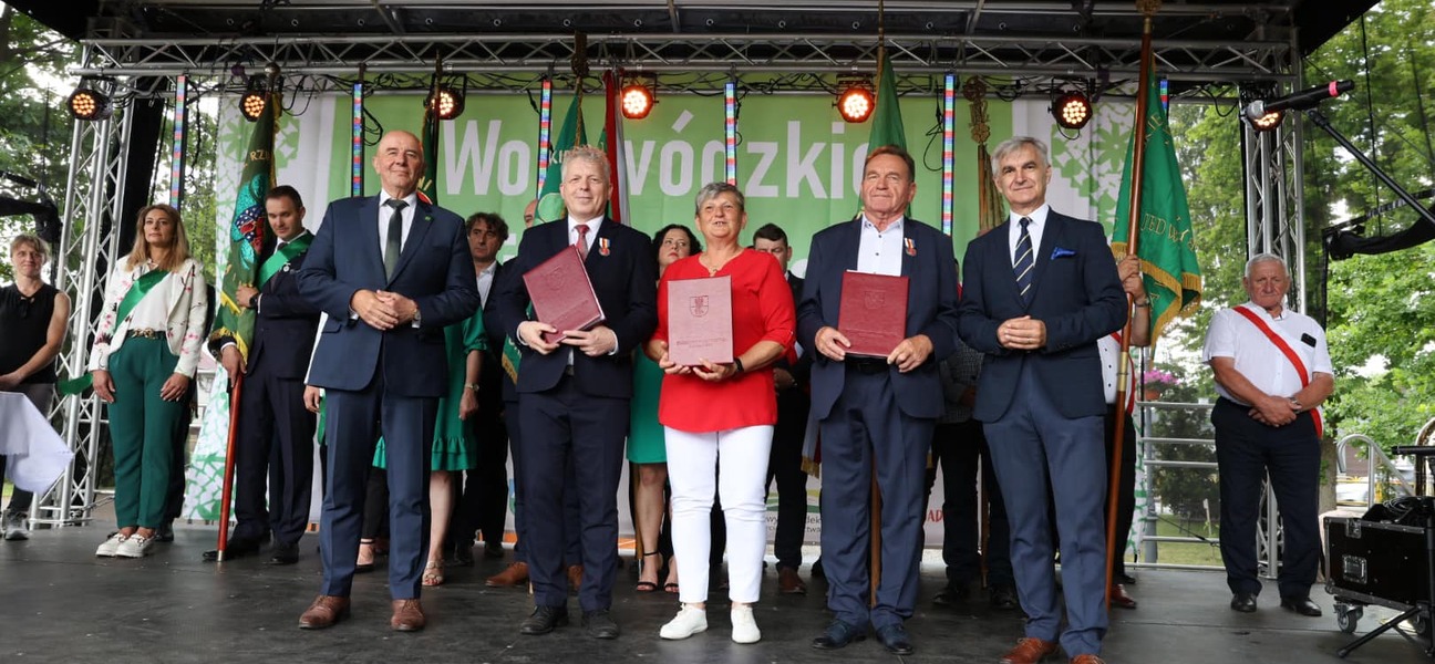 Laureaci odznak honorowych województwa na scenie z przedstawicielami samorządu.
