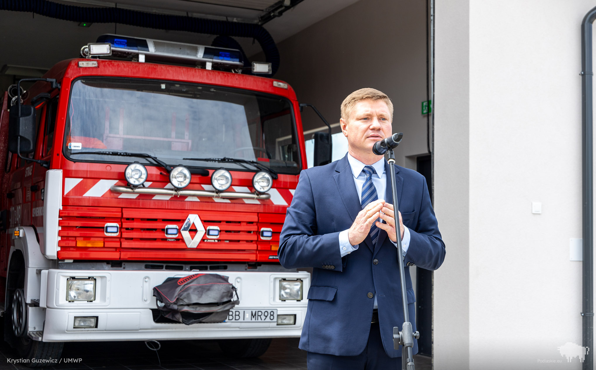 Marek Malinowski przed wozem strażackim