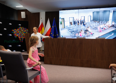 Rzecznik województwa oprowadza dzieci po sali konferencyjnej urzędu wojewódzkiego.
