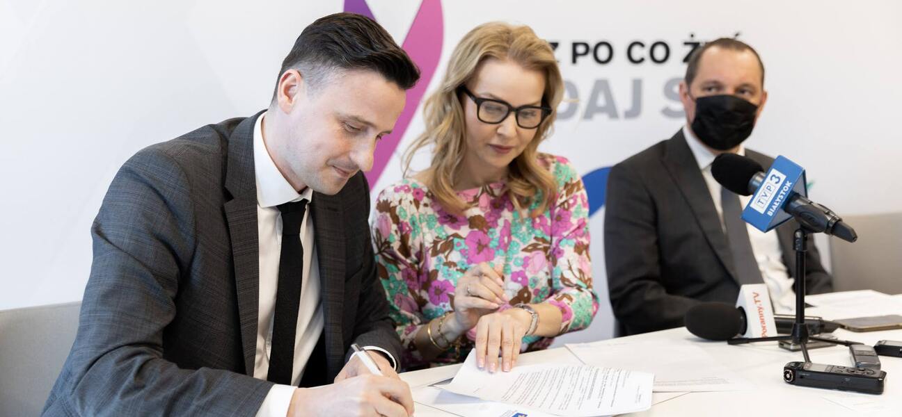 Od lewej: Andrzej Sowa i Magdalena Borkowska podpisują umowy. Obok siedzi Dominik Maślach.