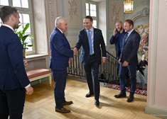Minister Radosław Sikorski ściska dłoń z prezydentem Truskolaskim