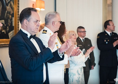 Ambasador Chorwacji oraz mundurowi i kobieta ubrana w na biało klaszczą