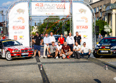 Zwycięzcy rajdu, sponsorzy oraz organizatorzy pozują do zdjęcia przy bramce oraz samochodach