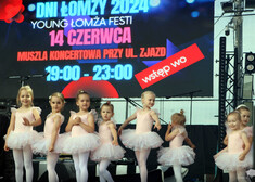 Dziewczynki w strojach baletnic stojące przed projektorem.