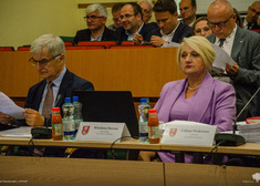 Wiesława Burnos i Bogdan Dyjuk siedzą przy stole.