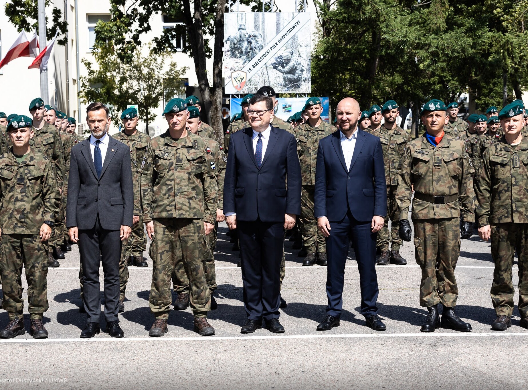 Oficjele stoją na zdjęciu z grupą żołnierzy