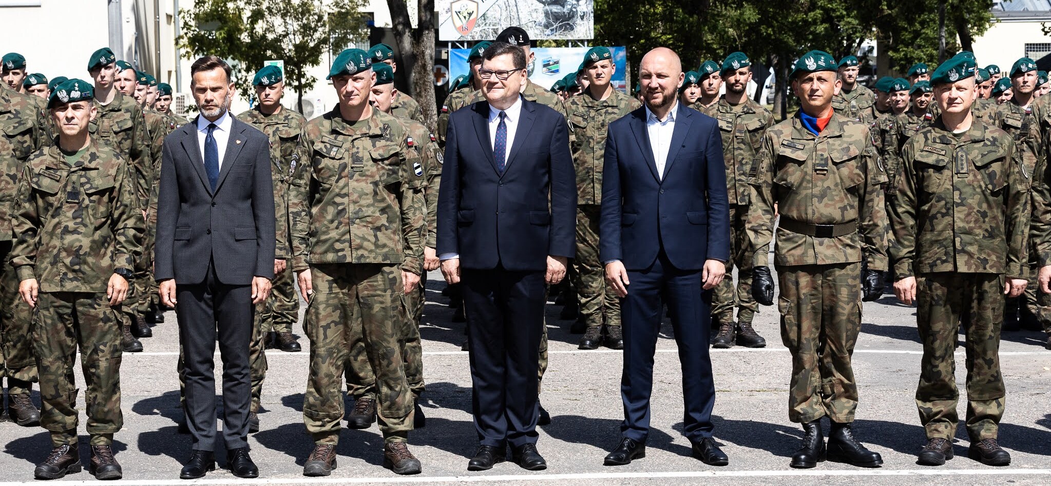 Oficjele stoją na zdjęciu z grupą żołnierzy