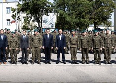 Oficjele stoją na zdjęciu grupowym z żołnierzami 