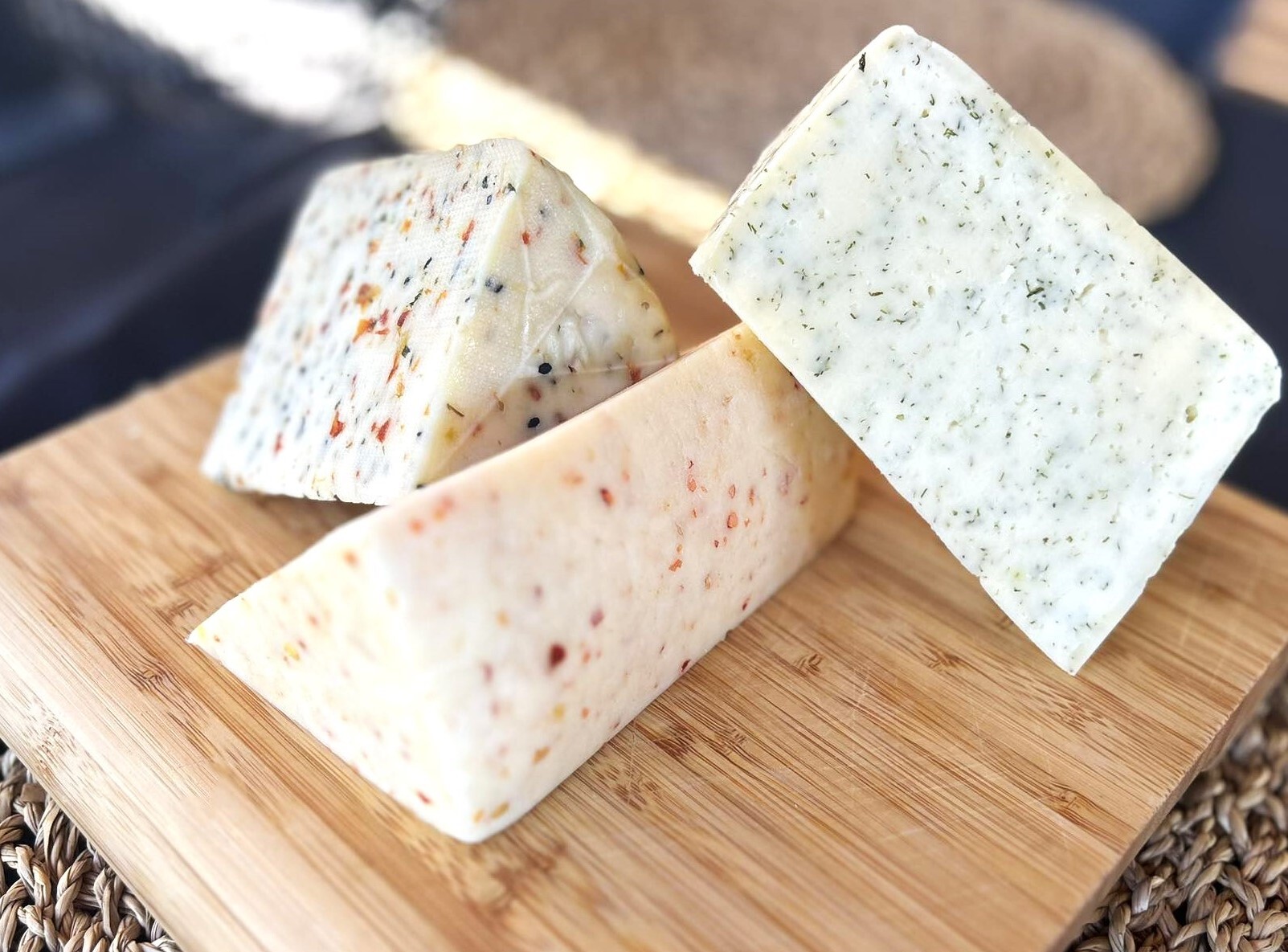 Trzy trójkątne kawałki sera ułożone na desce