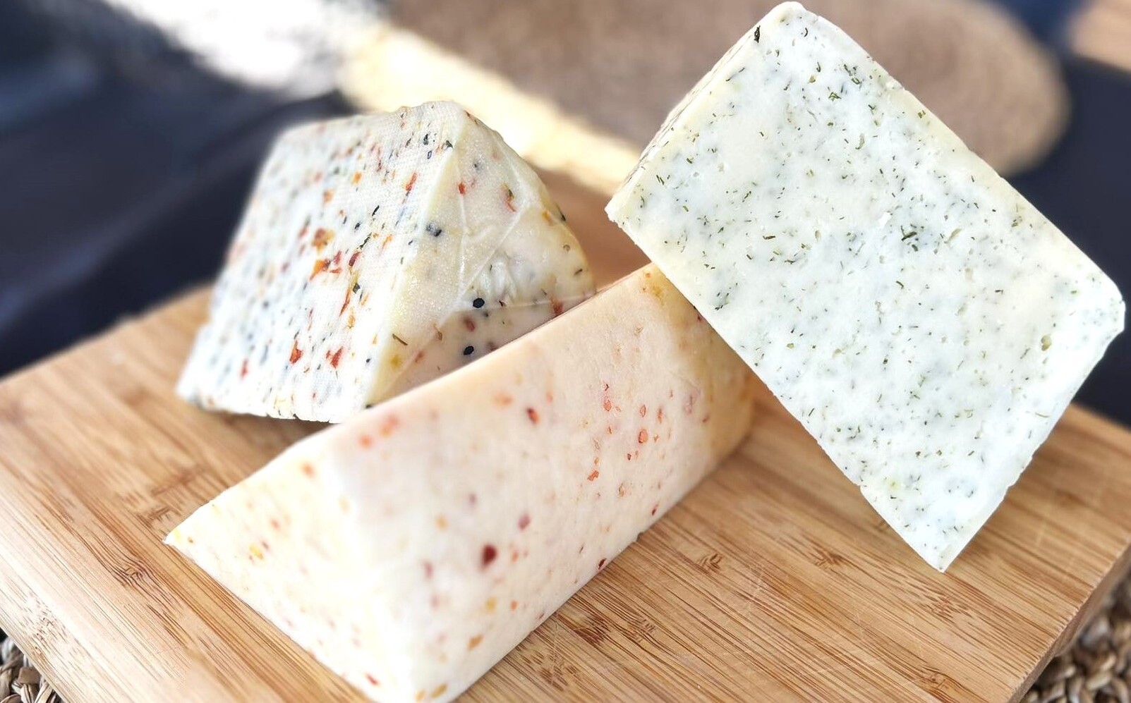 Trzy trójkątne kawałki sera ułożone na desce