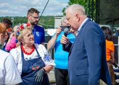 Redaktor Marek Sierocki zwraca się do kobiety ubranej w strój ludowy