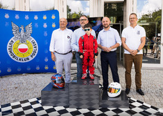 Oficjele wraz z dzieckiem stoją na podium.