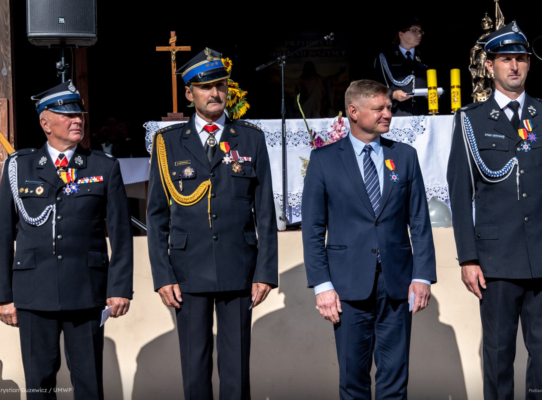 Marek Malinowski stoi obok strażaków.