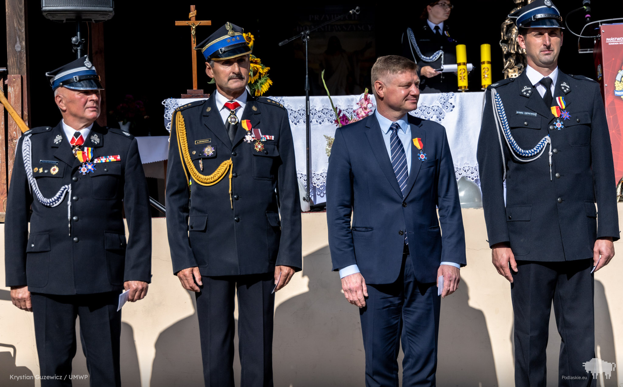 Marek Malinowski stoi obok strażaków.