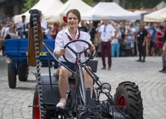 Staroświecki pojazd rolniczy z kobietą za kierownicą.