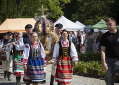 Korowód z wieńcami przemaszerowuje ścieżką.