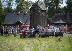 Traktor przejeżdża przed wiatrakiem.