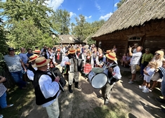 Ludzie w strojach ludowych grają muzykę.