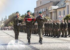 Żołnierze maszerują z flagą