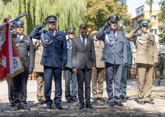 wojewoda i przedstawiciele służb salutują przed pomnikioem.