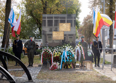 Żołnierze stojący przed wieńcami.