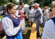 Cezary Cieślukowski rozmawia z kobietą przy ławce.