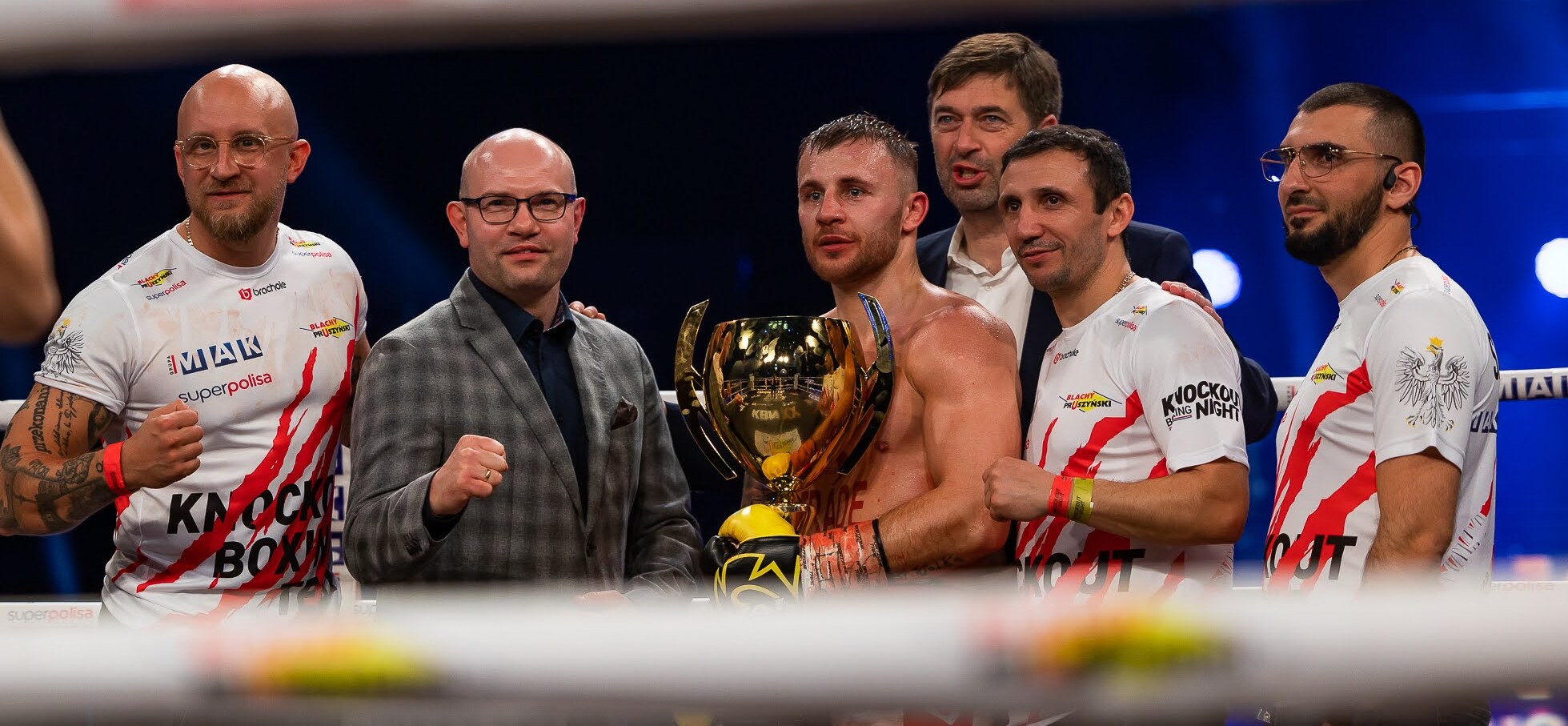 Marszałek Artur Kosicki wraz z zawodnikami pozuje do zdjęcia na ringu
