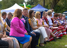 Ludzie siedzą na ławkach.