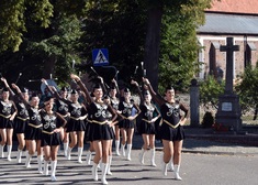 Młode dziewczyny maszerują w takt muzyki granie przez orkiestrę