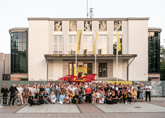 Grupa osób przed budynkiem teatru