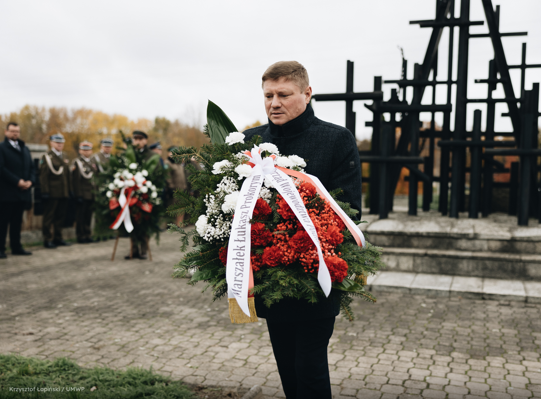 Mężczyzna składa wieniec