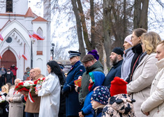 Grupa osóbh przed bramą kościoła