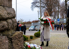 Kobieta niesie biało-czerwony wieniec