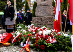 Biało-czerwone wiązanki przed pomniekim. 