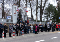 Grupa osóbh przed bramą