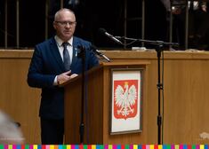 Andrzej SKierpko zabiera głos za mównicą z godłem Polski