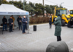 Grupa osób na placu ze sprzętem drogowym