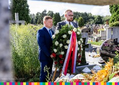 Marek Malinowski i Sebastian Łukaszewicz składają wieniec na grobie.