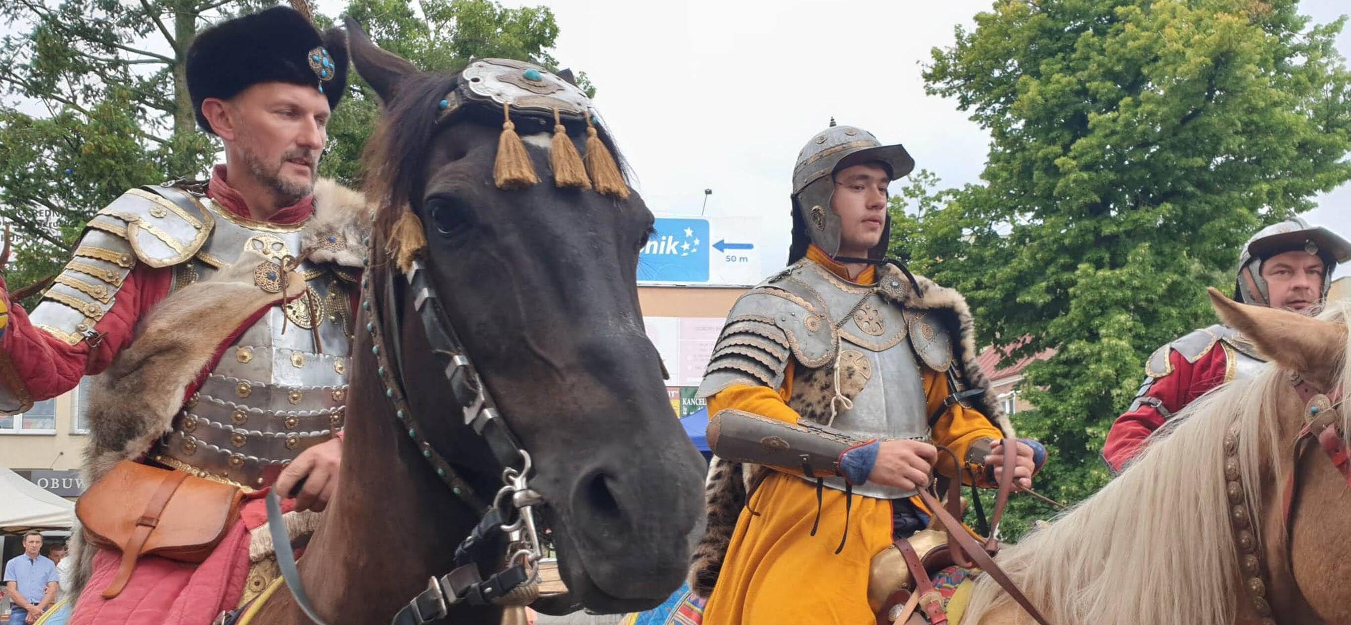 dwóch mężczyzn w historycznych strojach siedzą na koniach